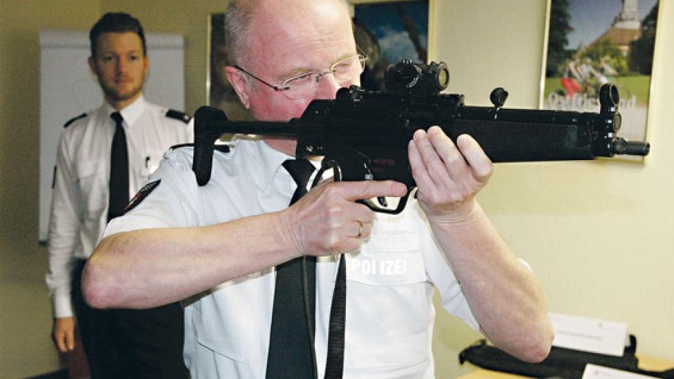 »Unsere stärkste Waffe ist das Wort«, betonte Polizeidirektor Johannes Lind. Der Inspektionsleiter scheut sich aber nicht, im Bedarfsfall auch zum handfesten Exemplar zu greifen. Im Beisein von Pressesprecher Christoph Kettwig (im Hintergrund) zeigte Lind, dass eine Maschinenpistole 5 zu den Einsatzmitteln der Beamten gehört. © Foto: Szyska