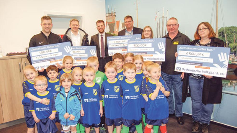 5000 Euro auf fünf Schecks: Von links Andreas Schoormann (TuS Weener), Markus Janssen (TuS Holthusen), Justus Lüttmann (OVB), Matthias Adler (TV Bunde), Anna Fischer, Bodo Scheffer (beide »Filmfreunde«) und Andrea Pastoor (»Streunerkatzen«). Vorne im Bild die Kinder der G-Jugend des TuS Weener bei der Spendenübergabe. © Foto: Hoegen