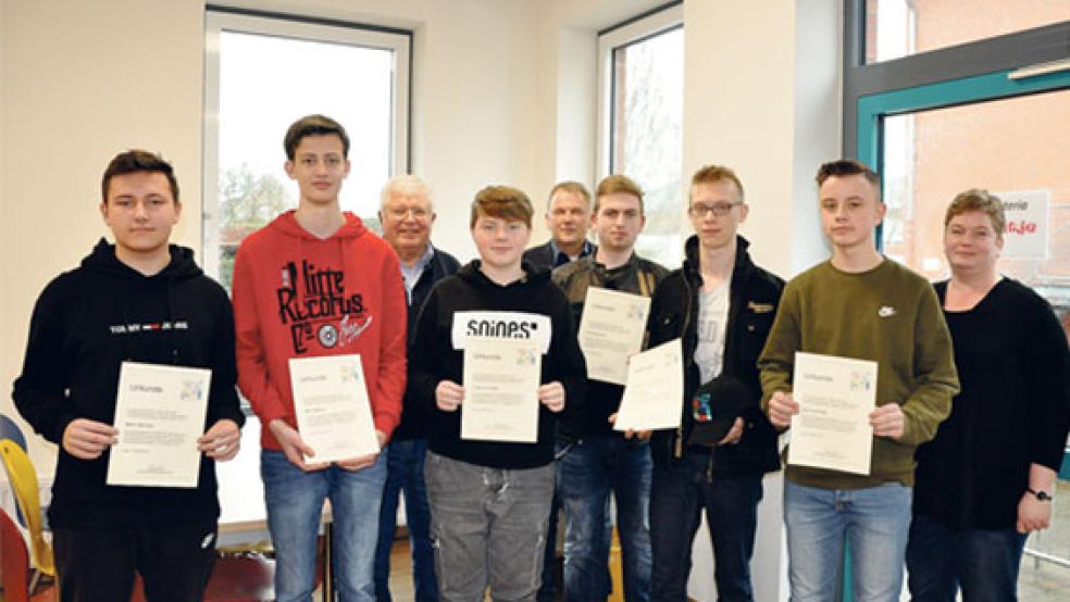 Die sechs Oberschüler aus Bunde Björn Jäschke, Mirko Bakker, Thies-Luka Derr, Jan Boelmann, Lucas Mertens und Dario Huisinga (von links) erhielten eine Urkunde. An der Veranstaltung nahmen auch Folkert Laupichler (Volksbund Deutsche Kriegsgräberfürsorge), Bürgermeister Gerald Sap und Schulleiterin Karin Wingbermühle (im Hintergrund von links) teil.  © Foto: Boelmann