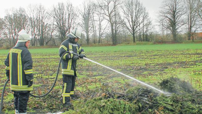 Feuerwehr löscht brennenden Strauchschnitt