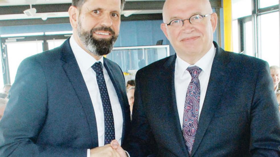 Mit ihren Unterschriften und einem kräftigen Händedruck besiegelten heute im Emssperrwerk bei Gandersum Umweltminister Olaf Lies (links) aus Hannover und »Provinzminister« Henk Staghouwer aus Groningen das strategische »Leitbild für den Ems-Dollart-Bereich«. © Foto: Kuper