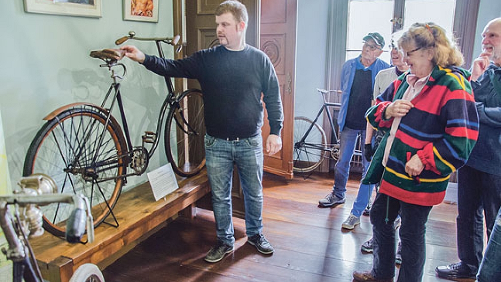 »Erfahrener« Kenner der Radfahr-Geschichte in Ostfriesland: Dinus Voss (links) führt eine Gruppe durch die Ausstellung.  © Foto: Hanken