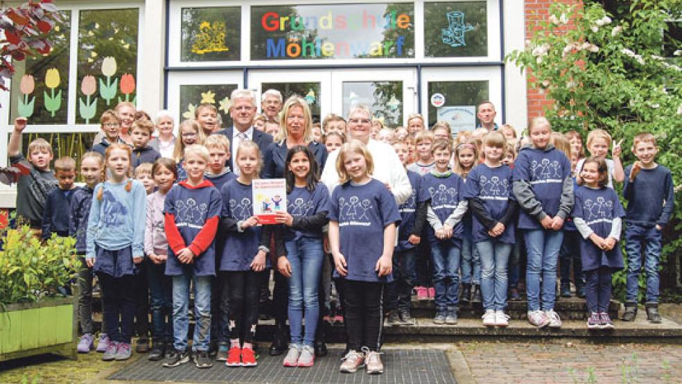 Stolz auf die Auszeichnung sind die Schülerinnen und Schüler der Grundschule Möhlenwarf. Im Bild auch (von links) Bürgermeister Ludwig Sonnenberg, Schulleiterin Mechthild Tammena und Hildegard Hinderks, Kreisvorsitzende des Sozialverbandes. Im Vordergrund halten zwei Schülerinnen die Plakette, die rechts neben dem Schuleingang angebracht wird. © Foto: Hoegen