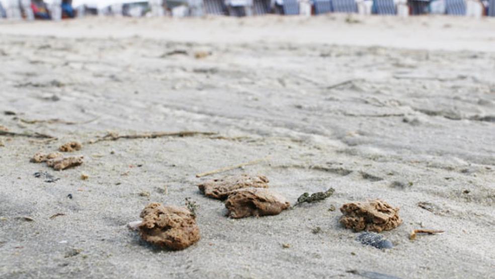 Klumpen eines bislang unbekannten Materials - wie hier am Strand von Norderney - wurden nun auch auf dem Festland gefunden. © Foto: Volker Bartels (dpa)