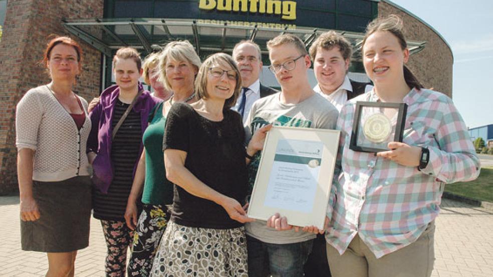 Stolz präsentierten Schüler und Lehrkräfte der Weeneraner Pestalozzischule gestern Nachmittag vor dem Besucherzentrum der Unternehmensgruppe Bünting in Nortmoor ihre Urkunde und ihre Medaille der Johann Bünting-Stiftung. Unser Bild zeigt (von links) die pädagogische Mitarbeiterin Iris Engl, Tessa Busboom, (verdeckt) Monika Meinders vom Begleitenden Dienst des Altenzentrums Rheiderland, die ehemalige Lehrerin Sylvia Hempel, Lehrerin Anke Schrader, Stiftungsvorstand Peter Detmers, Andre Klaaßen, Kai Willems und Denise Grosse. © Foto: Szyska