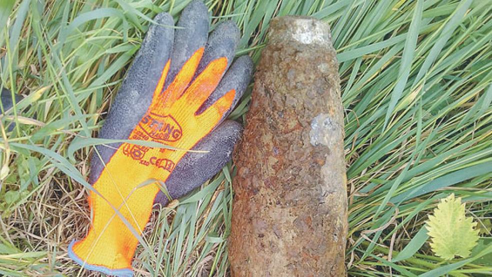 Der Vergleich mit dem Handschuh verdeutlicht die Größe der Flakgranate, die heute in Bunderhammrich gesprengt wurde. © Foto: Mohr (Kampfmittelbeseitigungsdienst Niedersachsen)
