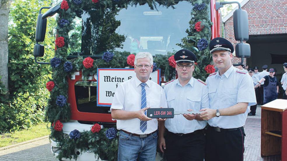 Bürgermeister Sonnenberg übergab dem Stadtbrandmeister aus Weener, Jörg Fisser, und dem Ortsbrandmeister von Weenermoor, Wilhelm Heijen (von links), feierlich den symbolischen Schlüssel für das neue Feuerwehrauto. © Foto: Berents