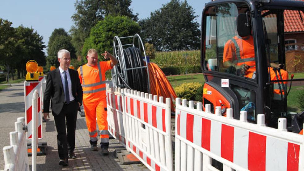 Glasfaser-Ausbau: Landrat Matthias Groote (links) besuchte eine Baustelle in Lammertsfehn. Christian Albers, Mitarbeiter der Firma Post, erklärte den aktuellen Stand. © Foto: Landkreis Leer