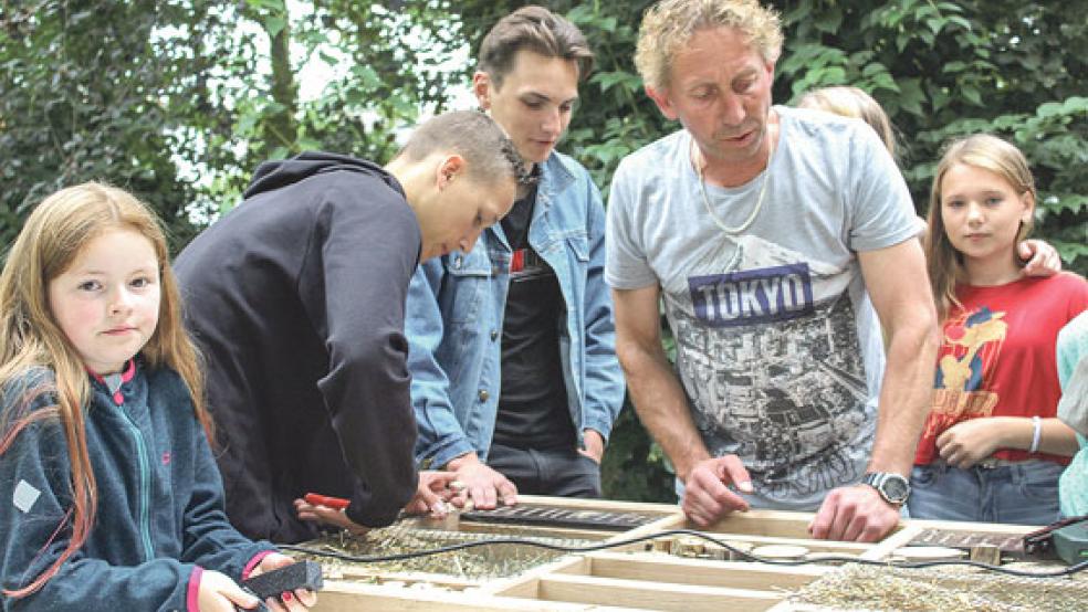 Frank Meinders aus Jemgum beaufsichtigte am Mittwoch die Kinder aus Weißrussland beim Zusammenbau des Insektenhotels für den Wierde Park.  © Fotos: Berents
