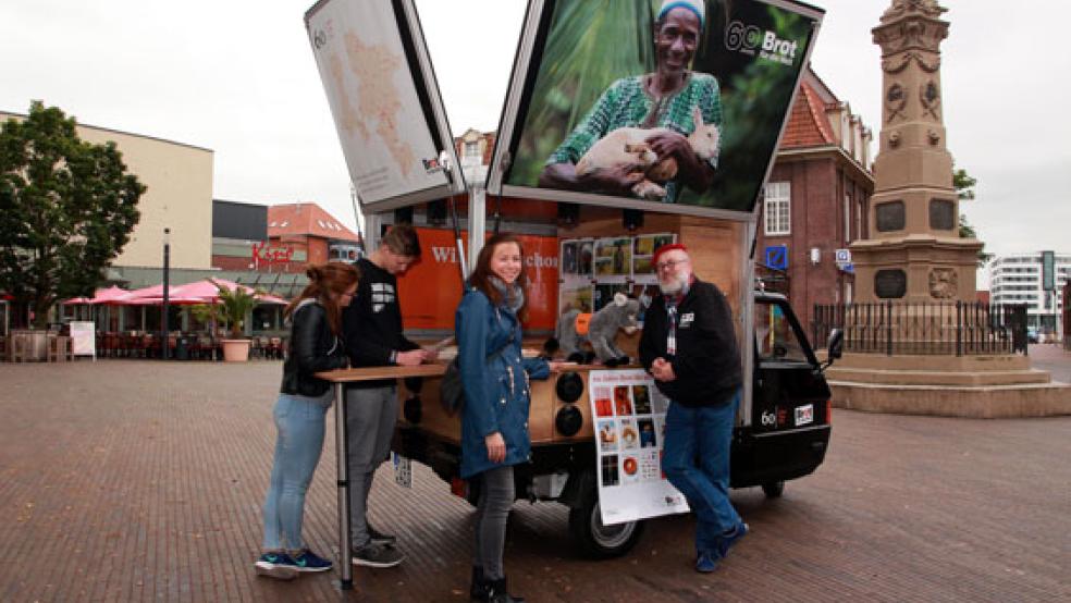 Uwe Becker (rechts), machte mit der »rollenden Litfaßsäule« des »Brot-für-die-Welt«-Hilfswerkes Station auf dem Denkmals­platz in Leer. Dort begrüßte ihn Pastorin Leska Meyer aus Warsingsfehn. Über die Arbeit des Hilfswerkes informierten sich auch Yasmin Blume aus Magdeburg und Colin Zölzer aus Wetter (links). © Foto: Dübbel/Kirchenkreis