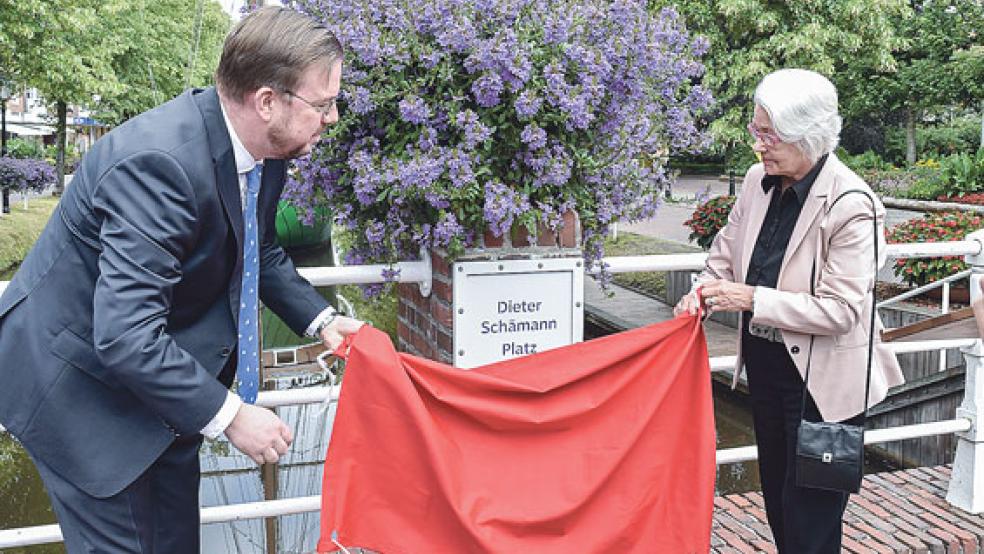 Papenburgs Bürgermeister Jan Peter Bechtluft und Anneliese Schämann (rechts) enthüllten gemeinsam das Schild, dass nun den Dieter Schämann Platz am Hauptkanal ausweist.  © Foto: Ute Müller