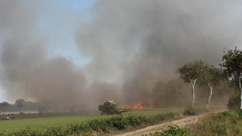 In hellen Flammen steht dieser Mähdrescher, die Feuerwehr ist in Fahne in der Gemeinde Ihlow mit einem Großaufgebot im Einsatz, da sich das Feuer tief in den Moorboden hinein gefressen hat.  © Foto: Feuerwehr