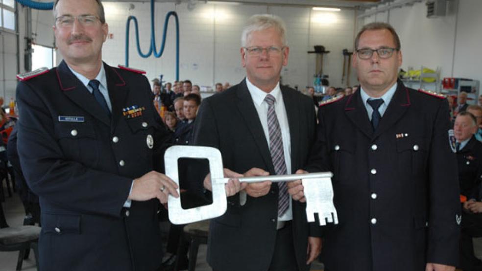 Symbolische Schlüsselübergabe: Ortsbrandmeister Hans-Joachim Kotulla als »Hausherr« (links) und Stadtbrandmeister Jörg Fisser (rechts) bekamen heute von Bürgermeister Ludwig Sonnenberg die offizielle »Schlüsselgewalt«. © Foto: Szyska