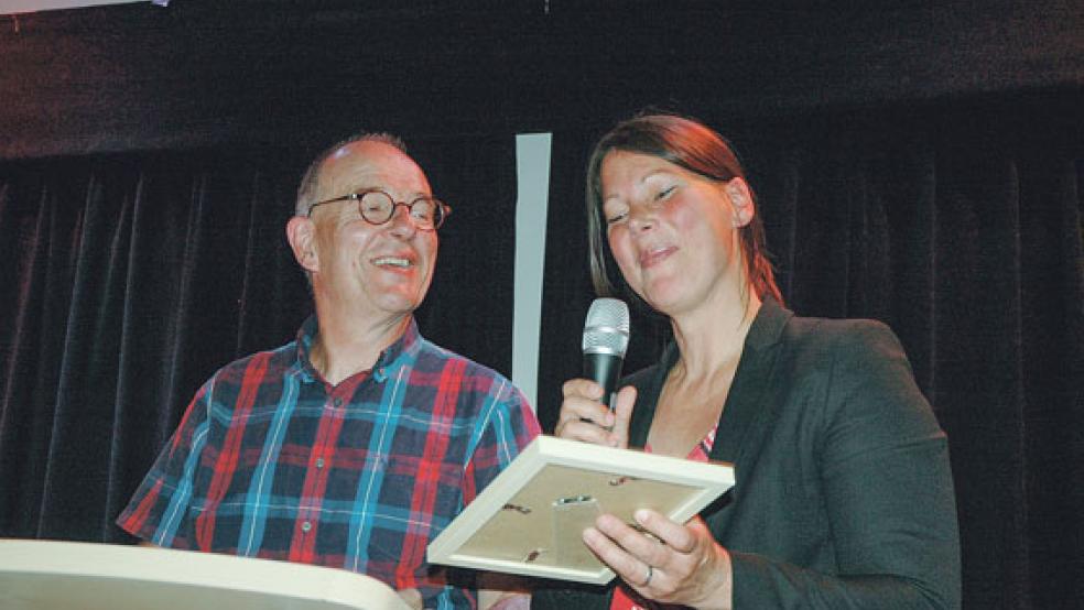 Die Superintendentin des lutherischen Kirchenkreises Emden-Leer, Christa Olearius, bedankte sich bei Andreas Zumach mit einem Teepräsent und einer Stadtansicht von Leer für seinen faktenreichen Vortrag. © Foto: Szyska