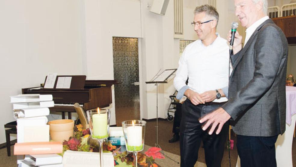 Blumen und Bücher: Heinz Zimmermann (rechts) präsentiert Marian Silaghi leere Buchhüllen, symbolisch für ein biblisches Software-Paket. Kleines Bild: Elke Stock (links) herzt Mariana Silaghi zum Abschied und überreicht einen Strauß.  © Fotos: Hanken