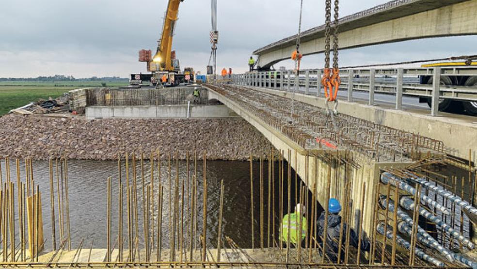 Millimeterarbeit mit dem Kran: Die letzten Brückenträger wurden eingehoben. Die tonnenschweren Beton-Fertigteile wurden vor zwei Wochen unter Vollsperrung mit Schwerlastkränen angeliefert. © Foto: Landesbehörde für Straßenbau und Verkehr (Aurich)