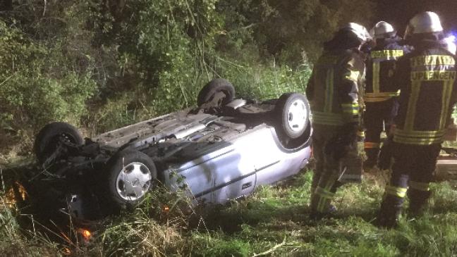 Junge Frau mit Arm unter Auto eingeklemmt