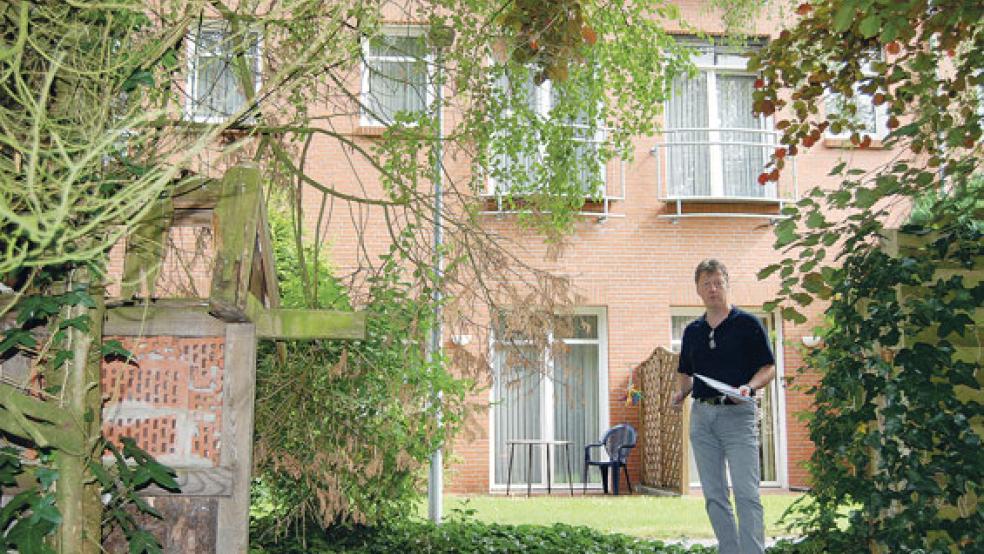 An das Gebäude des Altenzentrums im Hintergrund soll der Erweiterungsbau »angesetzt« werden, Geschäftsführer Andreas Cramer steht in dem Gartenbereich, der überbaut werden soll. © Archivfoto: Hoegen