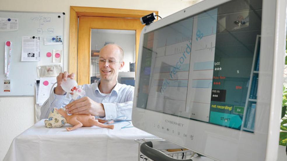 Hilbert Koetsier ist Geschäftsführer von »Applied Bio­signals« und von »ALD« in Weener. Er zeigt, wie eine Frühchen-Puppe beamtet wird. © Foto: Boelmann