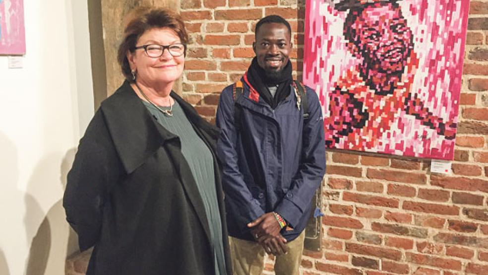 In Ghana lebt und arbeitet der Künstler Rufai Zakari, auf dem Foto mit der gastgebenden Galeristin Iris Gess und seinem nach Weener verkauften Werk »Save The Street II«.  © Kuper