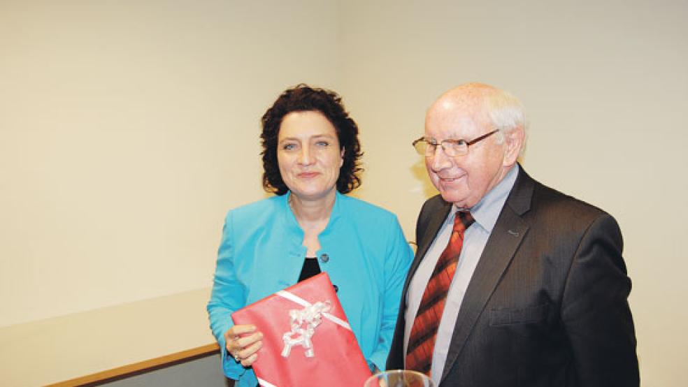 Mit einem Rheiderland-Bildband als Geschenk bedankte sich Jakobus Baumann bei Gesundheitsministerin Carola Reimann nach ihrem Vortrag vor den Vereinsmitgliedern. © Foto: Hoegen