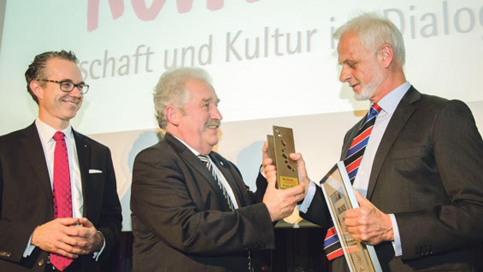 Helmuth A. Brümmer nimmt den Preis von Landschaftspräsident Rico Mecklenburg entgegen. Links: Staatssekretär Dr. Berend Lindner. Die Bronze­skulptur »Zusammen wirken« stammt von dem Künstler Thorsten Schütt aus Marx bei Friedeburg. Sie wurde von einer Jury aus zehn Vorschlägen ausgewählt. © Fotos: Hanken