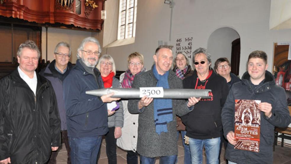 Eine Orgelpfeife als Symbol für den Geldsegen aus dem Erzähltheater »Der Atem Gottes«: Kai-Uwe Hanken (Mitte) und sein Team konnten dem Arbeitskreis für die Orgel-Sanierung 2500 Euro übergeben. Von links: Geerd Freerks, Wilhelm Rethmeier, Volker und Hanna Kraft, Karin Vry, Kai-Uwe Hanken, Marie-Christina Jhering, Harry de Winter (Effekte und Ton), Pastorin Inka Dohrmann-Westerdijk und Organist Ocko Grensemann. Es fehlt Famke Hanken (Darstellerin). © Foto: Boelmann