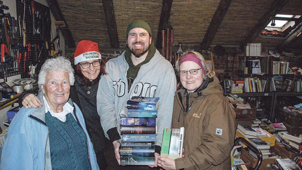 Elf Euro zugunsten der »Streunerkatzen« zahlten Michael Kudruß und Ute Kudruß (rechts) aus Bunde in »Wilms Bücherscheune« für Lesestoff im Neuwert von mehr als 200 Euro. Carola Dams-Ostendorp und Dini Dams (links) freuen sich über jeden Euro. © Fotos: Kuper