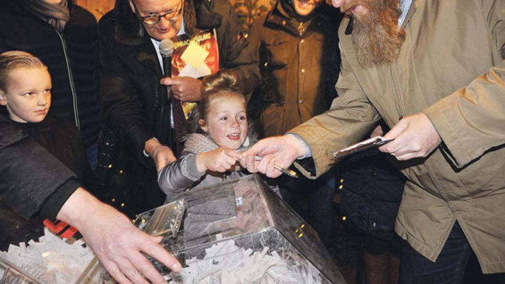 Jayson und Maureen an der Lostrommel. Hinter »Glücksfee« Maureen Werbegemeinschafts-Chef Johannes Poppen.  © Foto: Wolters