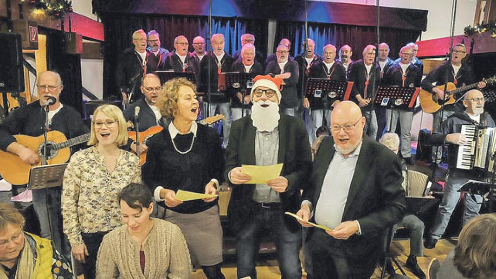 Gemeinsam mit dem »Bingumer Shanty Chor« und dem Publikum stimmten (stehend von links) Moderatorin Jessica Schlage, Bürgermeisterin Beatrix Kuhl, Moderator Andreas Kuhnt und Reeder Alfred Hartmann ein Weihnachtslied an. © Foto: Wolters