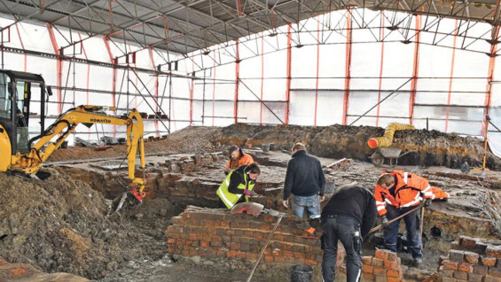 Dr. Kirsten Hüser (gelbe Jacke) und Team in Aurich während der Grabung, die jahreszeitlich bedingt unter einer Halle fortgesetzt wurde. © Foto: Former/Landschaft