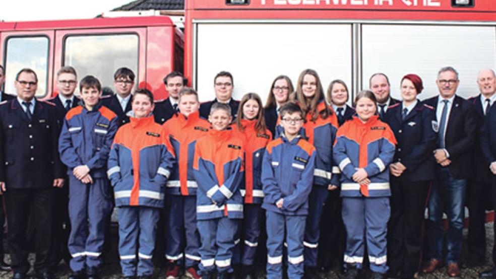 Die Mitglieder der Jugendfeuerwehr Holthusen mit einigen ihrer Betreuer und (von links) dem stellvertretenden Ortsbrandmeister Stefan Siemens, Stadtbrandmeister Jörg Fisser sowie (von rechts) dem stellvertretenden Kreisjugendfeuerwehrwart Jens Schmitt, Stadtjugendfeuerwehrwart Ewald Freese, dem stellvertretenden Bürgermeister Helmut Geuken, Jugendfeuerwehrwartin Mareike Riemeyer und dem stellvertretenden Jugendfeuerwehrwart Daniel Schmidt. © Foto: Rand (Feuerwehr)