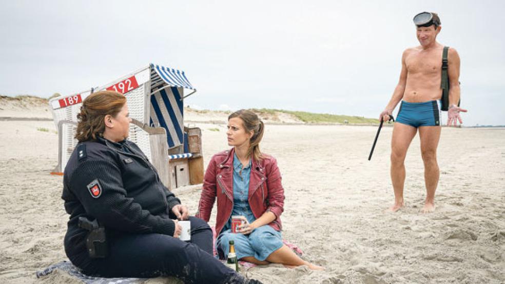 Am Strand von Norderney: Overbeck (Roland Jankowsky) überrascht Apothekerin Insa Scherzinger (Theresa Underberg, Mitte) und Inselpolizistin Grit Vierboom (Nadine Wrietz, links) mit seinem Besuch auf der Insel. © Foto: Thomas Kost (ZDF)