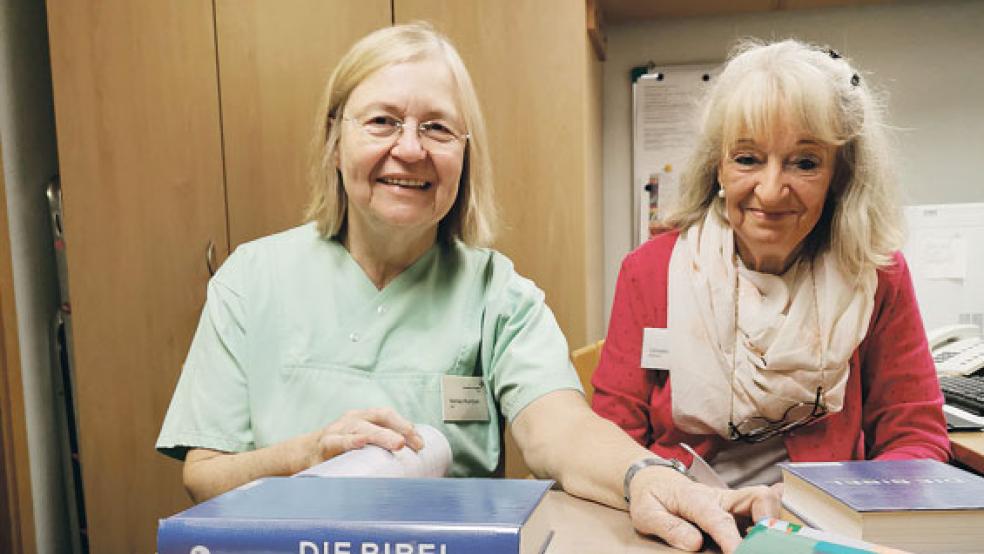 Marlies Rombald und Christine Sangen (von links) schlagen gemeinsam die neuen Bibeln ein. © Foto: Borromäus Hospital