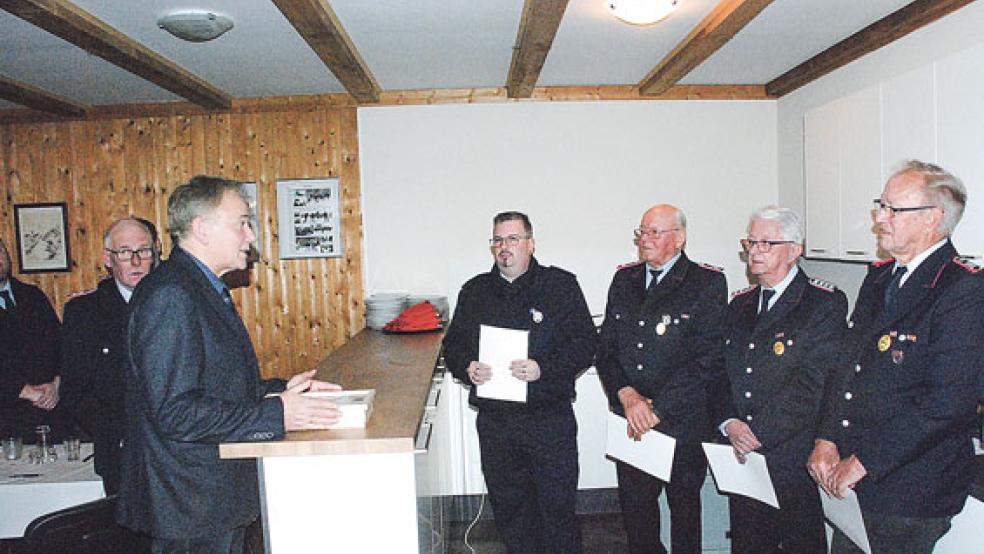 Bürgermeister Gerald Sap (links) ehrte vier langjährige Mitglieder der Freiwilligen Feuerwehr Dollart (von rechts mit Urkunde): Peter Freyborg (70 Jahre Mitglied), Karl-Heiko Metzler und Jürgen de Vries (beide 50 Jahre) sowie Martin Voß (25 Jahre).  © Foto: Kuper