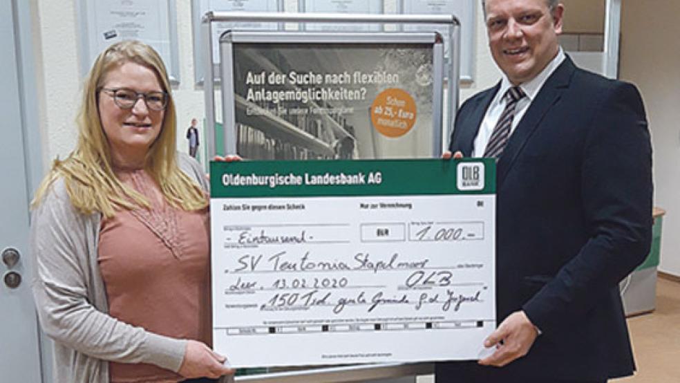 Lea Pannenborg (SV Teutonia Stapelmoor) nimmt die Spende von Hermann Kruse (OLB) entgegen. © Foto: OLB