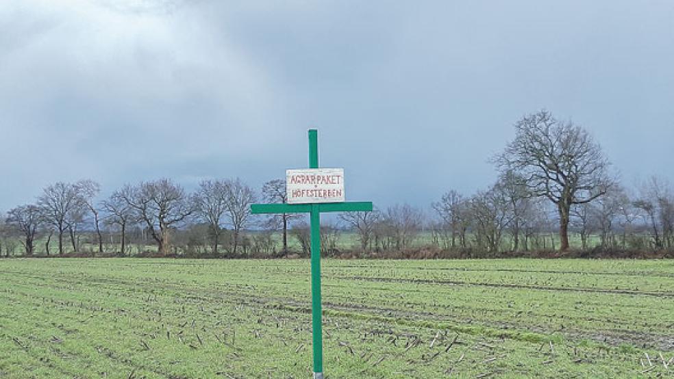 »Höfesterben«: Ein Mahnkreuz auf einem Feld am Ortseingang von Weener. © Foto: Hoegen