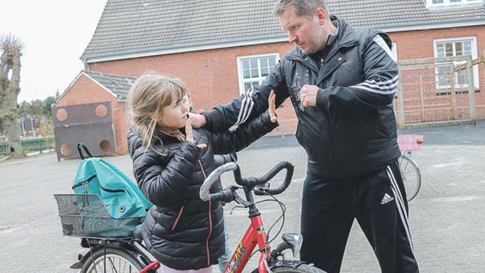 Jens Fricke trainierte mit den Kinder der Grundschule Ditzum Techniken der Selbstverteidigung. Hier übt er mit Nala Heimchen, sich nicht vom Fahrrad ziehen zu lassen.  © Foto: privat