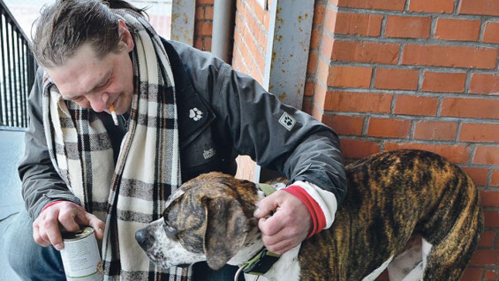 Holger und sein Hund »Gixxer« freuen sich über die Tüte mit frischen Äpfeln, Schokolade und Hundefutter. © Ammermann