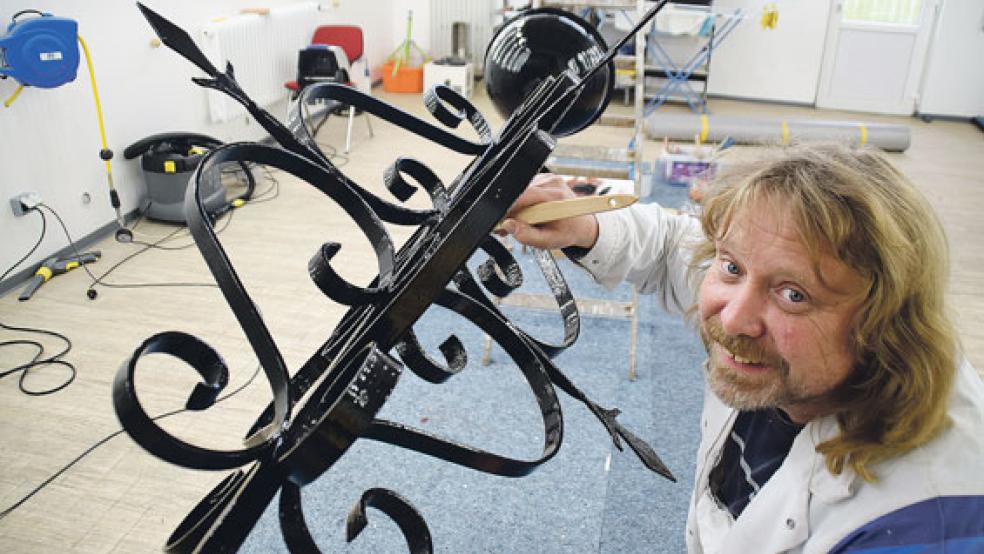 Der frischvergoldete Wetterhahn und Johann Dannen beim Lackieren des neuen Gestells. © Fotos: Himstedt