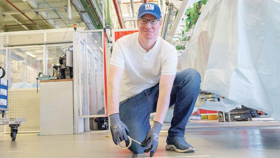 Vertrauensmann Hendrik Jansen aus der Montagehalle 7 klebt den Mindestabstand von 1,5 Metern für den Bereich »Frontend« ab.  © Foto: Volkswagen