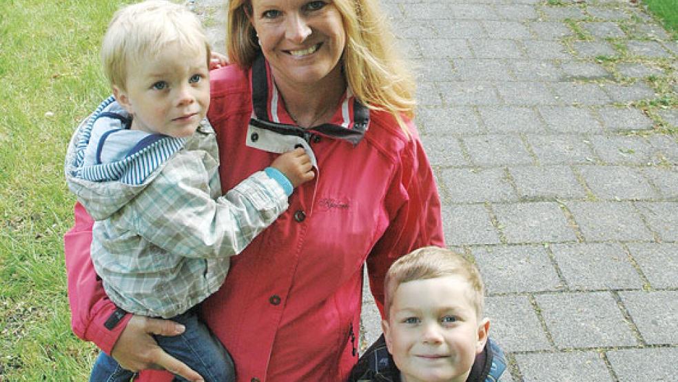 Initiatorin Anne Endjer und ihre Söhne Enno (2) und Imko (6) freuen sich, dass die Kette aus bunt bemalten Steinen immer länger wird. Am Rande des Fußwegs entlang des Friedhofs an der Matthäikirche in Bingum liegen mittlerweile über 500 kleine Hoffnungsträger. © Fotos: Szyska