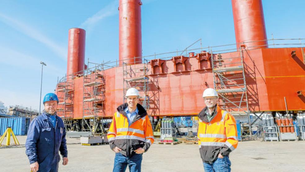 Betriebsratsvorsitzender Frank Hieronimus, Geschäftsführer Carsten Stellamanns und Fertigungsleiter Martin Gräfe (von links) vor einer ersten großen Sektion der künftigen Lachsfarm für die norwegische Küste. © Foto: Hasseler