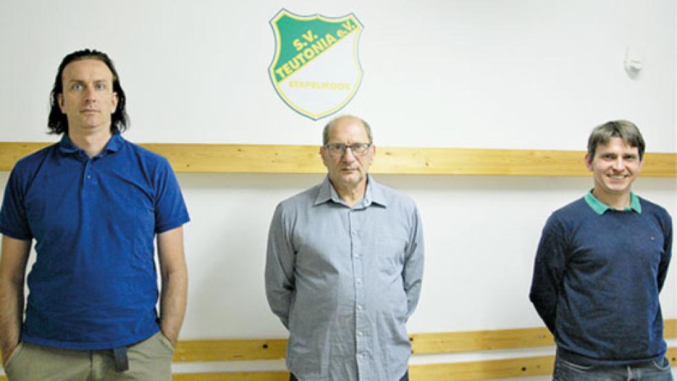 Herbert Waltemathe (Mitte), erster Vorsitzender des SV Teutonia Stapelmoor, und seine Stellvertreter, Micha Gerke (rechts) und Jürgen Siemens, in der neu gestrichenen Teutonia-Kabine. © Foto: Heinrich Siemons