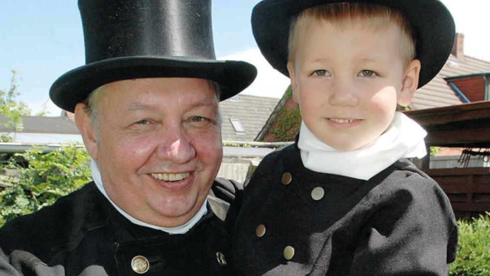 Im traditionellen Kehranzug freut sich Günter Harms auf seinen Ruhestand und auf mehr Zeit für den kleinen Luka. Wie es aussieht, möchte der Dreijährige später auch einmal Schornsteinfeger werden - wie sein Großonkel und seine Mama Stefanie Veldkamp. © Foto: Szyska
