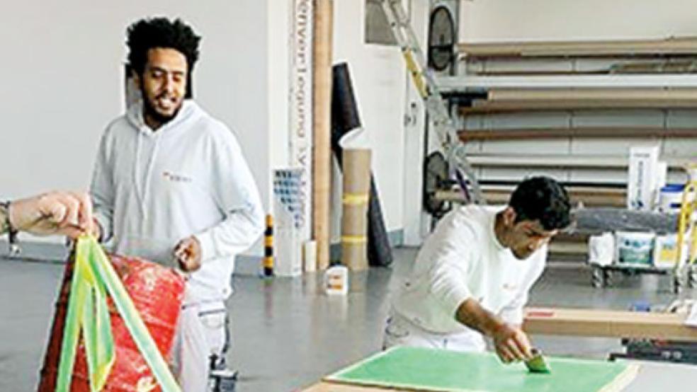 Michael Woldu und Amrullah Ahmadi (von links) in Aktion in der Werkstatt des Malereibetriebes Klinkenborg in Bunde.  © Foto: privat