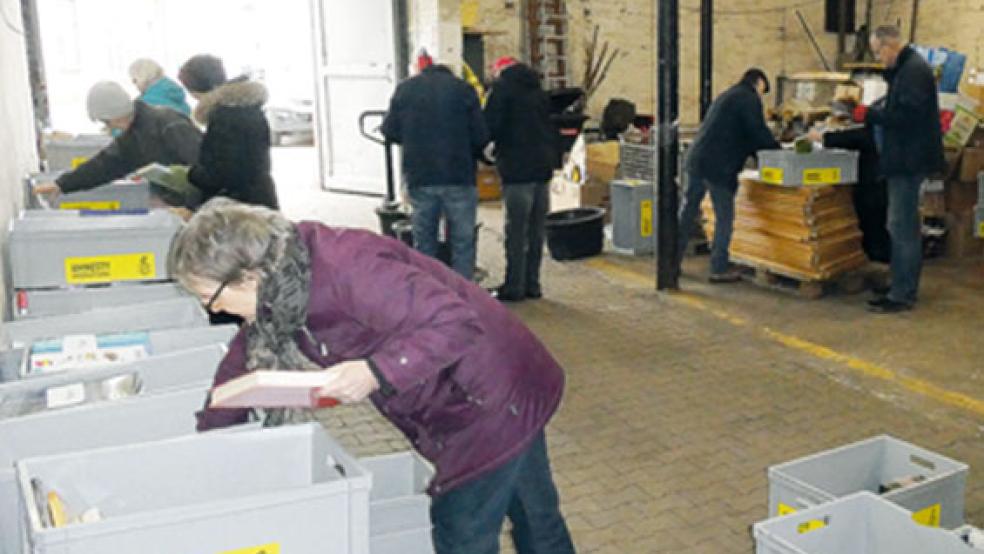 Mitglieder der ai-Gruppe Papenburg sortieren die gespendeten Bücher sorgsam nach Rubriken.  © Foto: Amnesty Papenburg