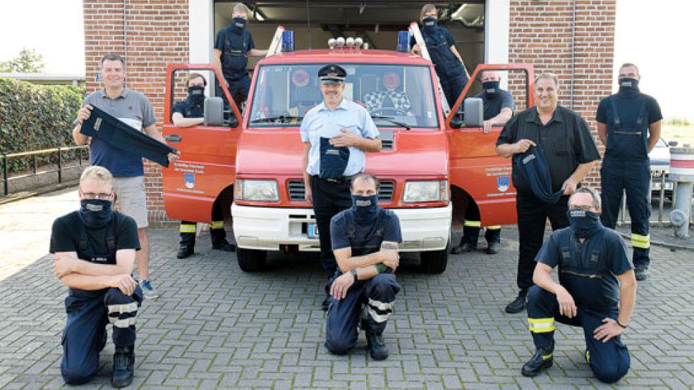 Dankbar für die Spende: Unser Foto zeigt einen Teil der Feuerwehrleute bei der Übergabe der Schals in Bunderhee inklusive Ortsbrandmeister Tobias Stirler (Mitte) mit den Spendern Michael Koenen (links) und Jan Oltrop. © Foto: Himstedt