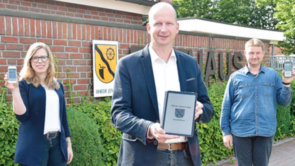 Haben die neue App schon auf ihren mobilen Geräten installiert (von links): Sozialausschuss-Vorsitzende Christine Langen, Bürgermeister Jens Willerding und Administrator Andre Bloem. © Foto: Müller 