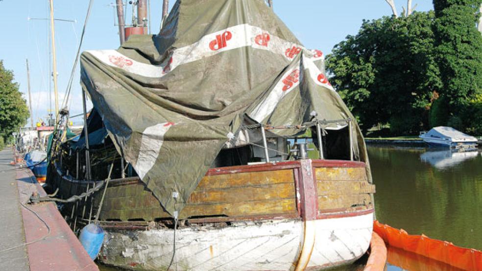 Die Aufbauten von Planen abgedeckt, entlang des Rumpfes sind Ölsperren verlegt. Für den ehemaligen Fischkutter »Miltiades« ist das Ende auf einer Abwrackwerft wohl gekommen. Noch liegt das Schiff im Hafen von Weener. © Hoegen